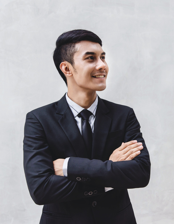 Portrait of Happy Businessman in Black Formal Suit. Standing by the Wall, Crossed Arms and Looking away